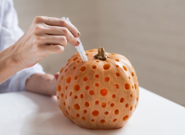 Cleaning carved pumpkin with pipe cleaner